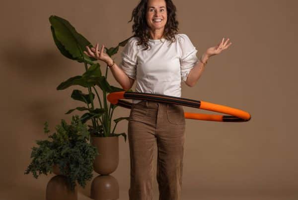 Angelique staat glimlachend met een oranje Bodyhoop om haar middel.
