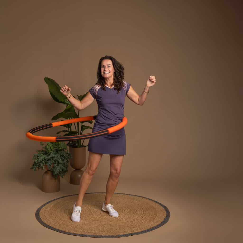 Angelique hoelahoepelt met de oranje-zwarte Bodyhoop.